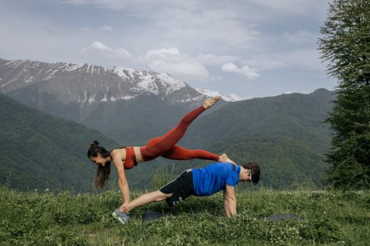 man and woman exercising on mountain top