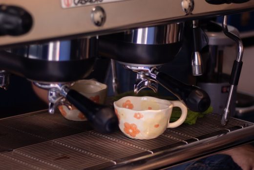 Những chiếc tách cà phê đặt trên máy pha espresso trong một quán cà phê