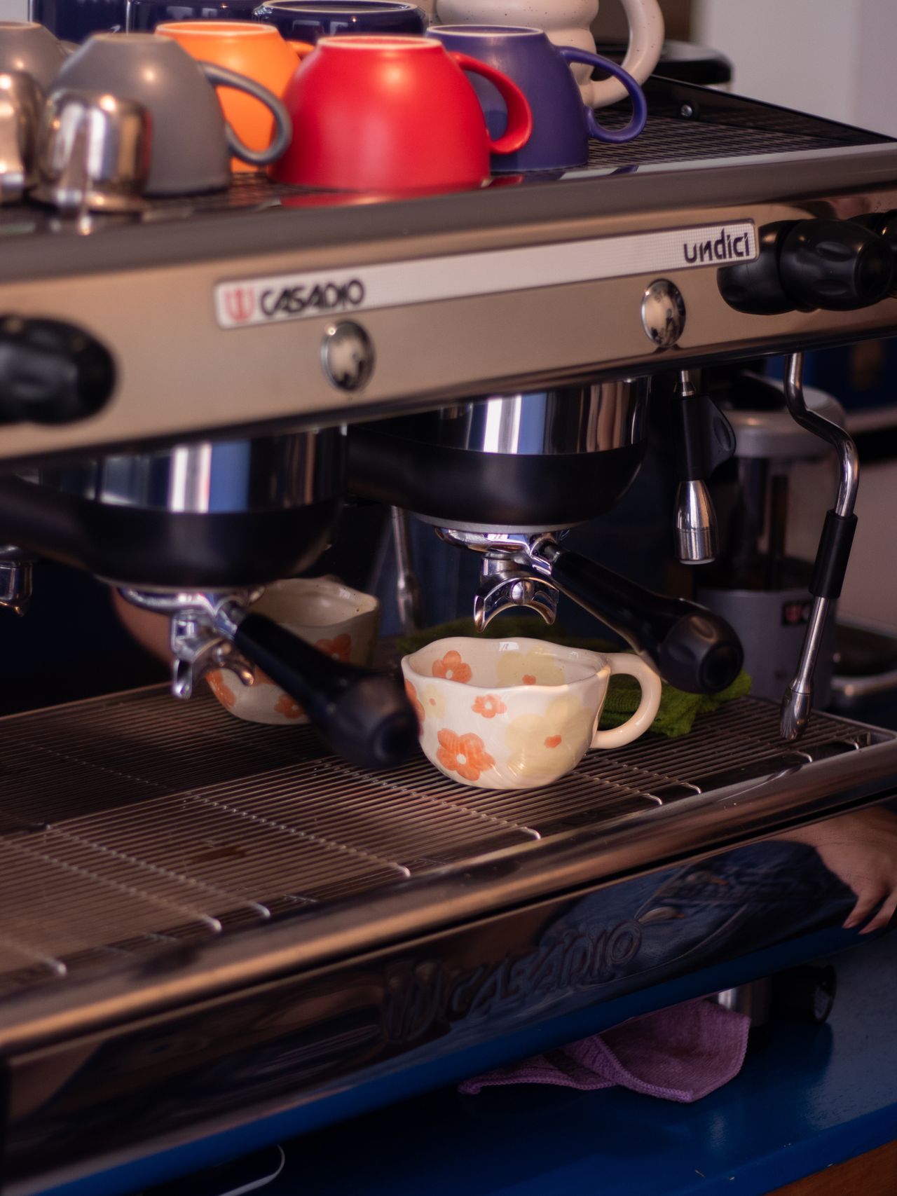 Những chiếc tách cà phê đặt trên máy pha espresso trong một quán cà phê